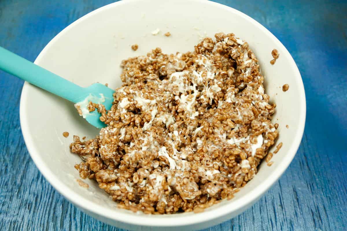 mix the melted marshmallows and chocolate rice krispies until well coated in a white bowl 