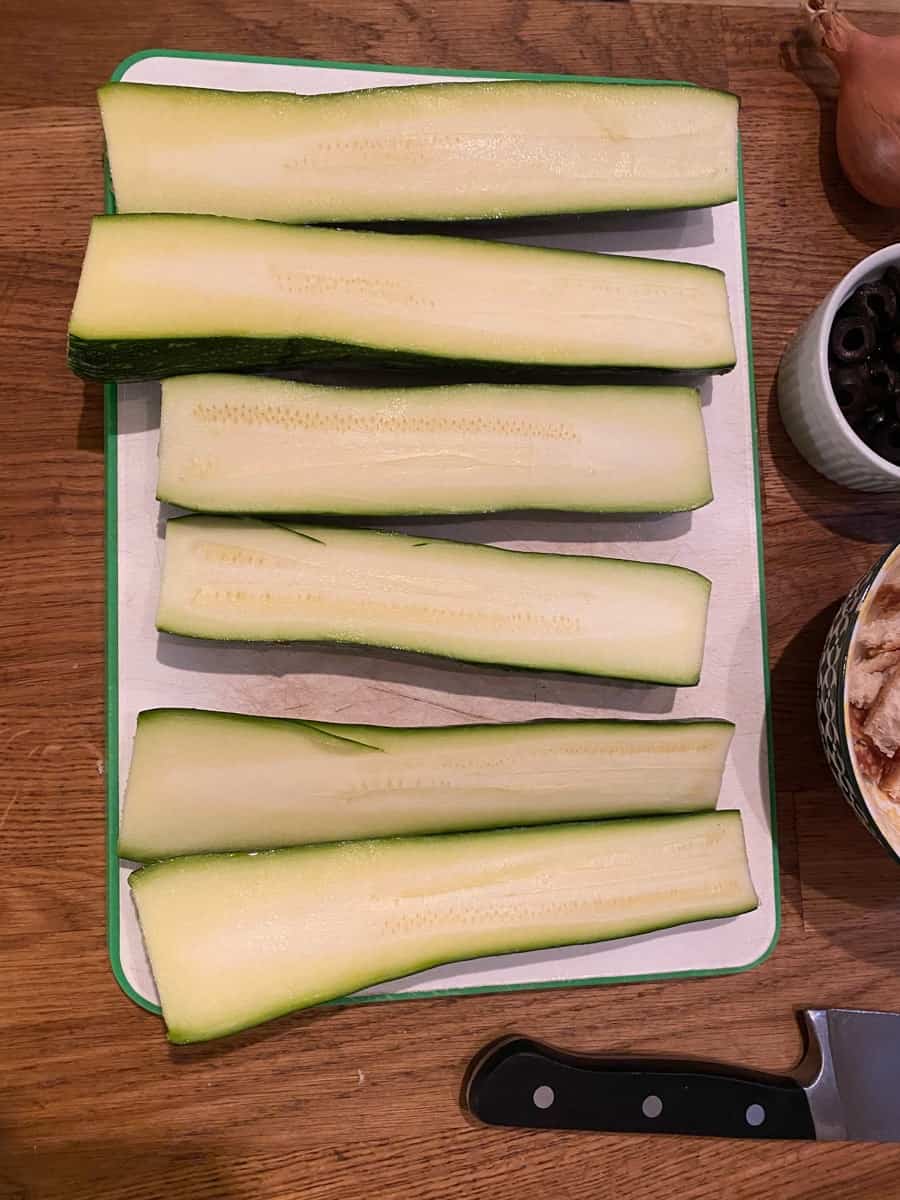 sliced zucchini on a white cutting board 