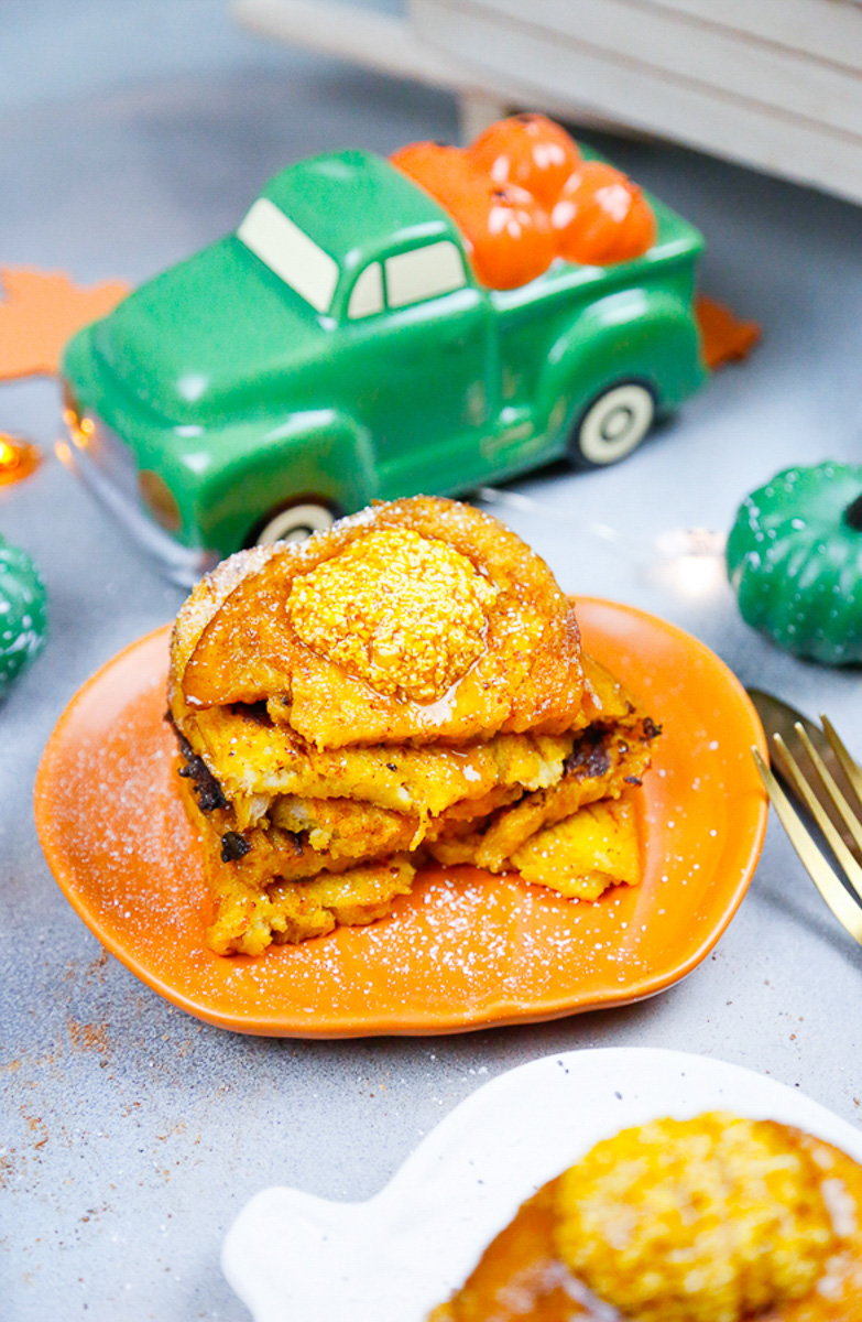 a stack of pumpkin brioche french toast topped with homemade pumpkin butter with a green truck with pumpkins on it