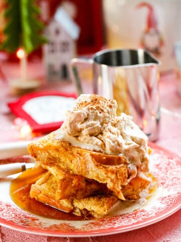 Baked eggnog french toast layers of french toast on a Christmas plate