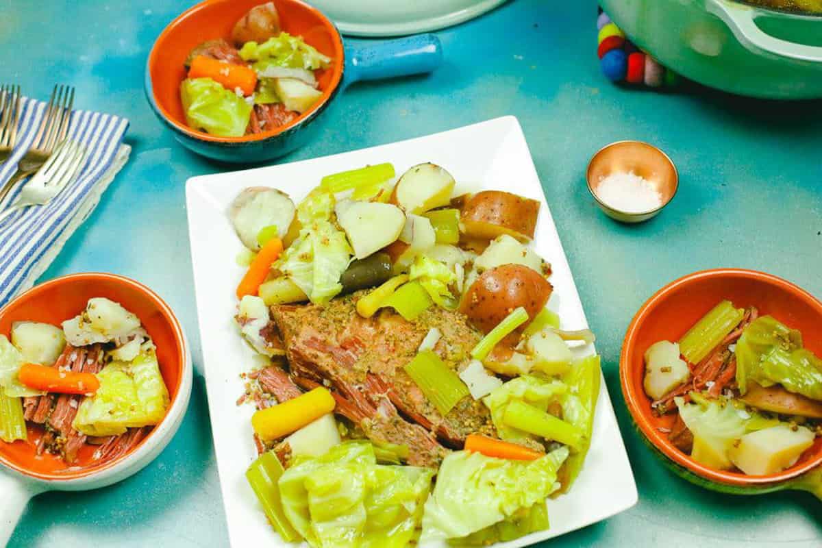 place the corned beef on a platter with cabbage, potatoes, celery, and carrots and get ready to serve 