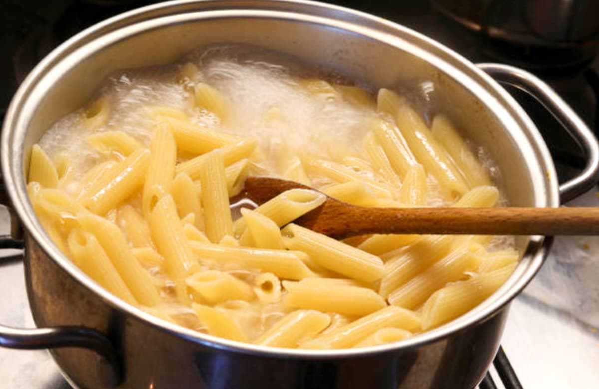cooked penne pasta in a pot of boiling water 