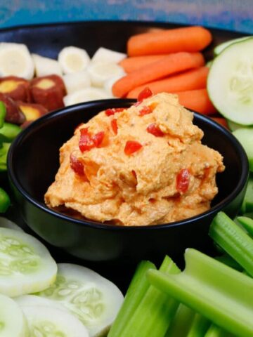 A tray of fresh veggies with homemade smoked pimento cheese with pimento on top