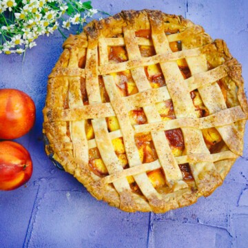 Golden brown pie made with a lattice crust and homemade peaches