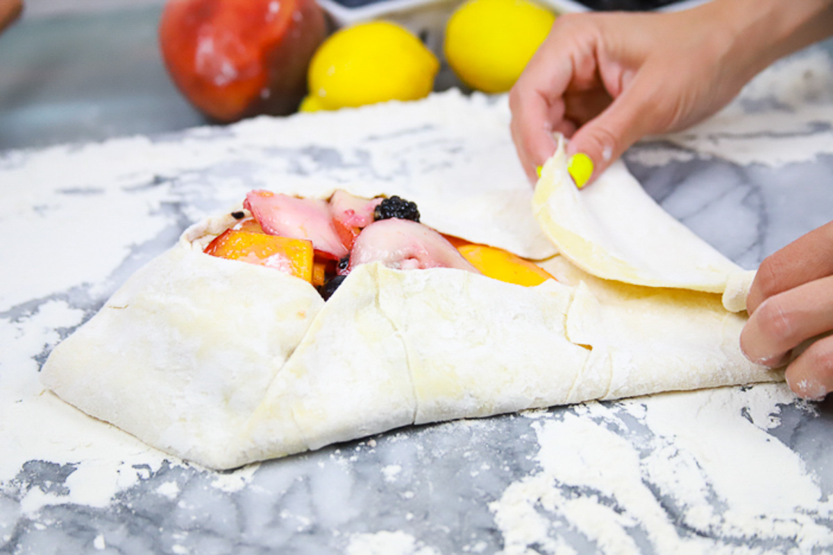 fold over each triangle of the pastry dough over the fruit, leaving the middle portion open. 