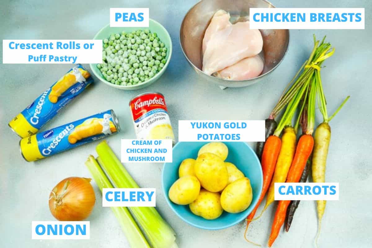 Ingredients for chicken pot pie with puff pastry, crescent rolls, chicken breasts, frozen peas, Yukon Gold potatoes, carrots, onion and cream of mushroom chicken soup