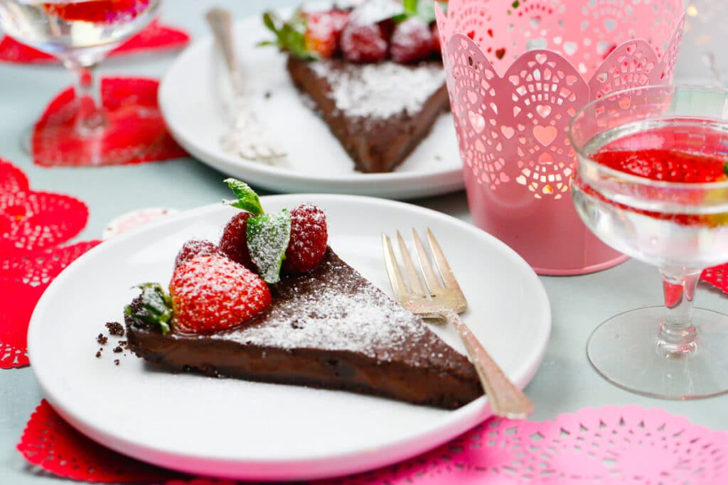 A heavenly slice of chocolate coffee ganache tart topped with fresh strawberries and raspberries and sprigs of mint. 