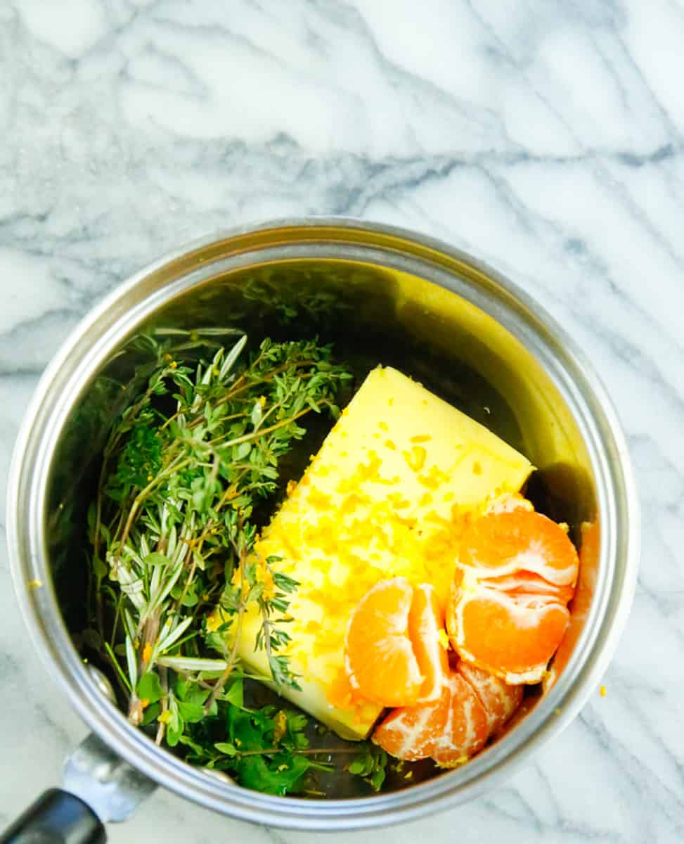 Irish butter, fresh herbs, Mandarin orange, in a saucepan