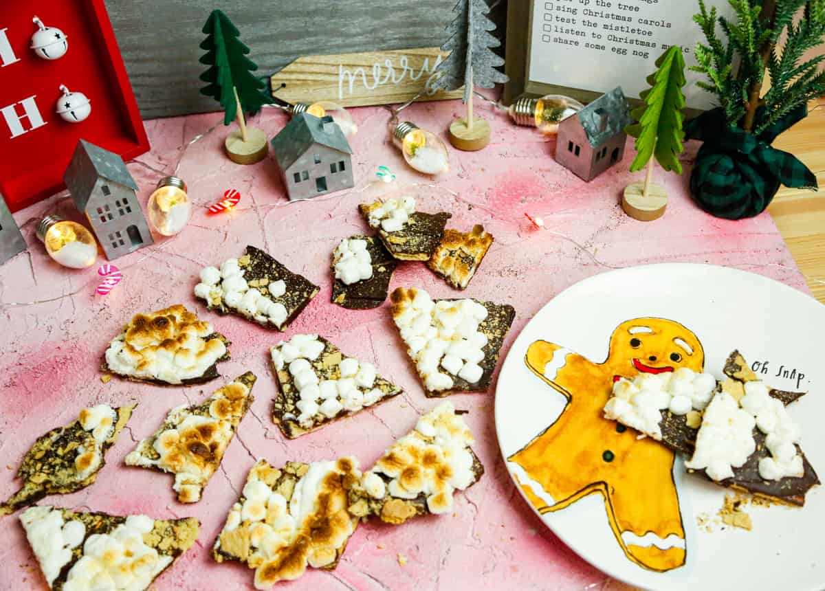 S'more bark broken into pieces on a gingerbread plate that reads Oh Snap! 