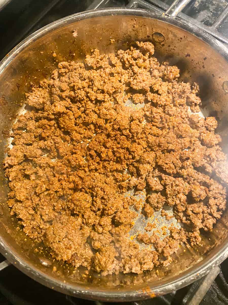browning ground beef in a metal pan on the stovetop 