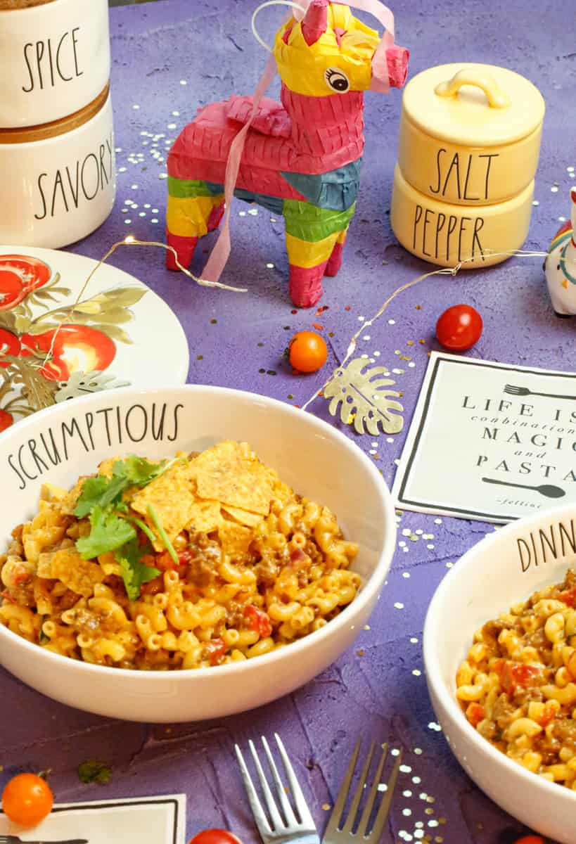 a bowl of taco pasta casserole on a purple backdrop and props 