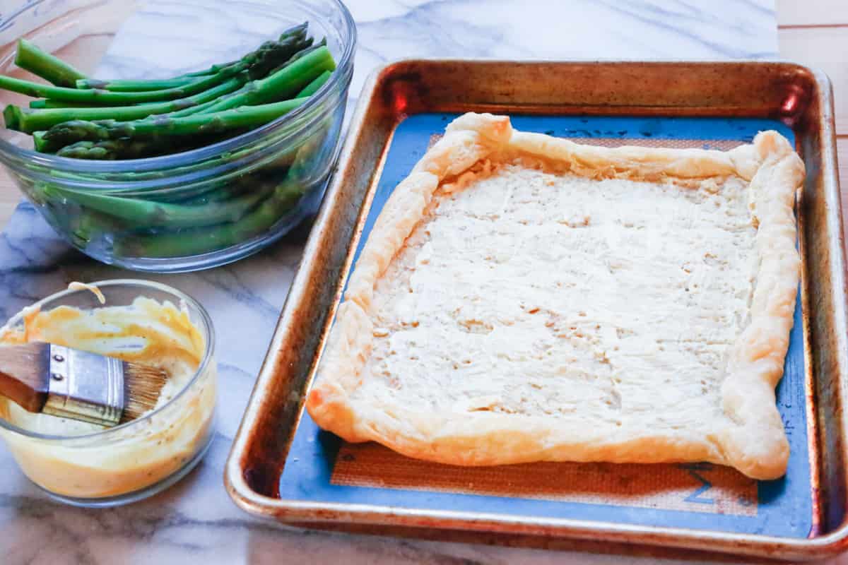 sauce spread on prepared puff pastry 