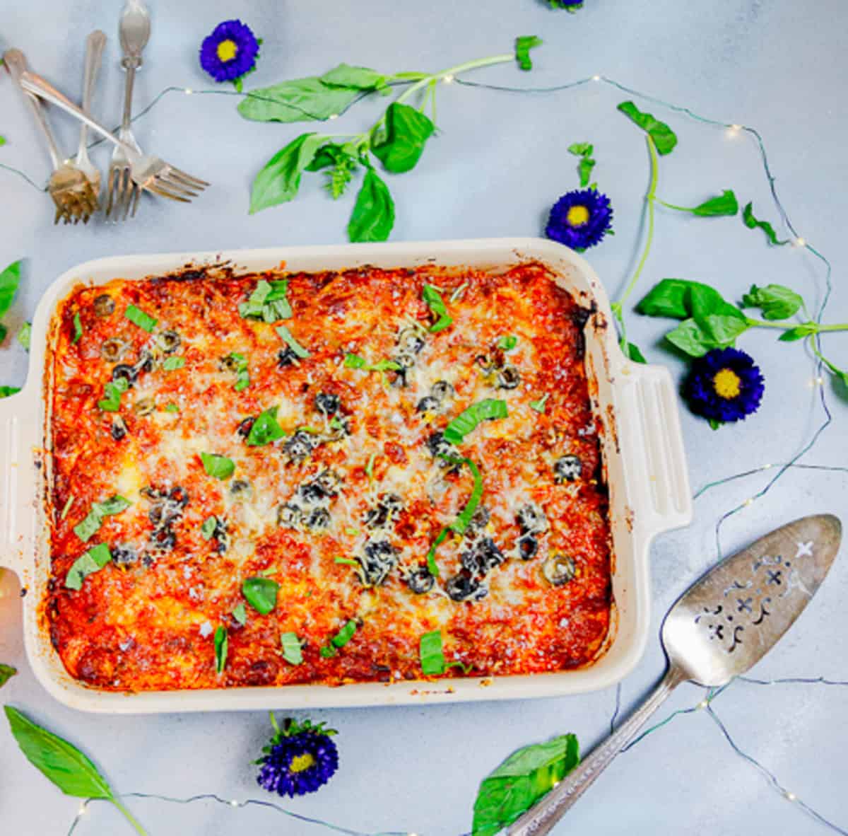 zucchini casserole in a baking dish with a serving spoon 