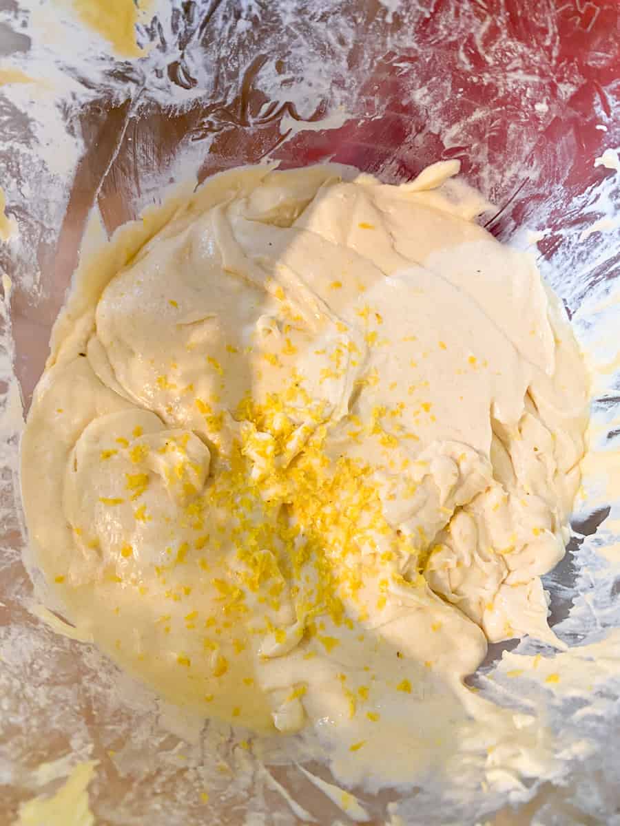 lemon bundt cake batter in a stand mixer with lemon zest