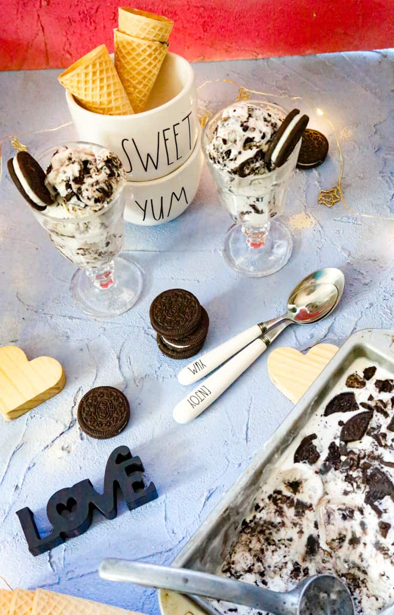 ice cream cones with oreo ice cream and a love sign with two spoons and a tray of oreo ice cream 