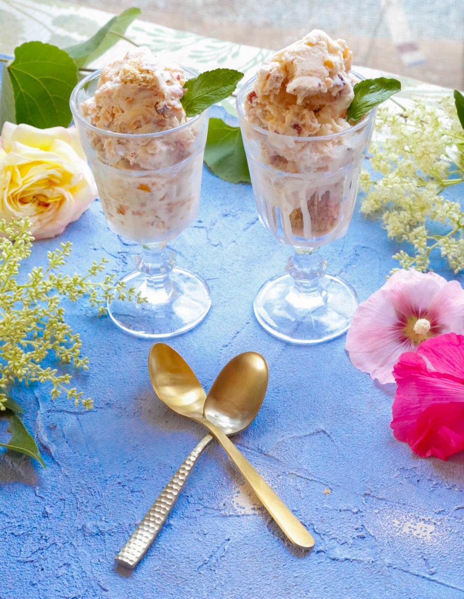 two sundae glasses filled with peach ice cream 