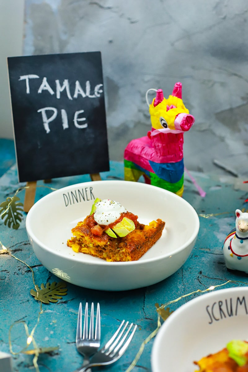 a slice of Texas Tamale Pie topped with avocado and sour cream 