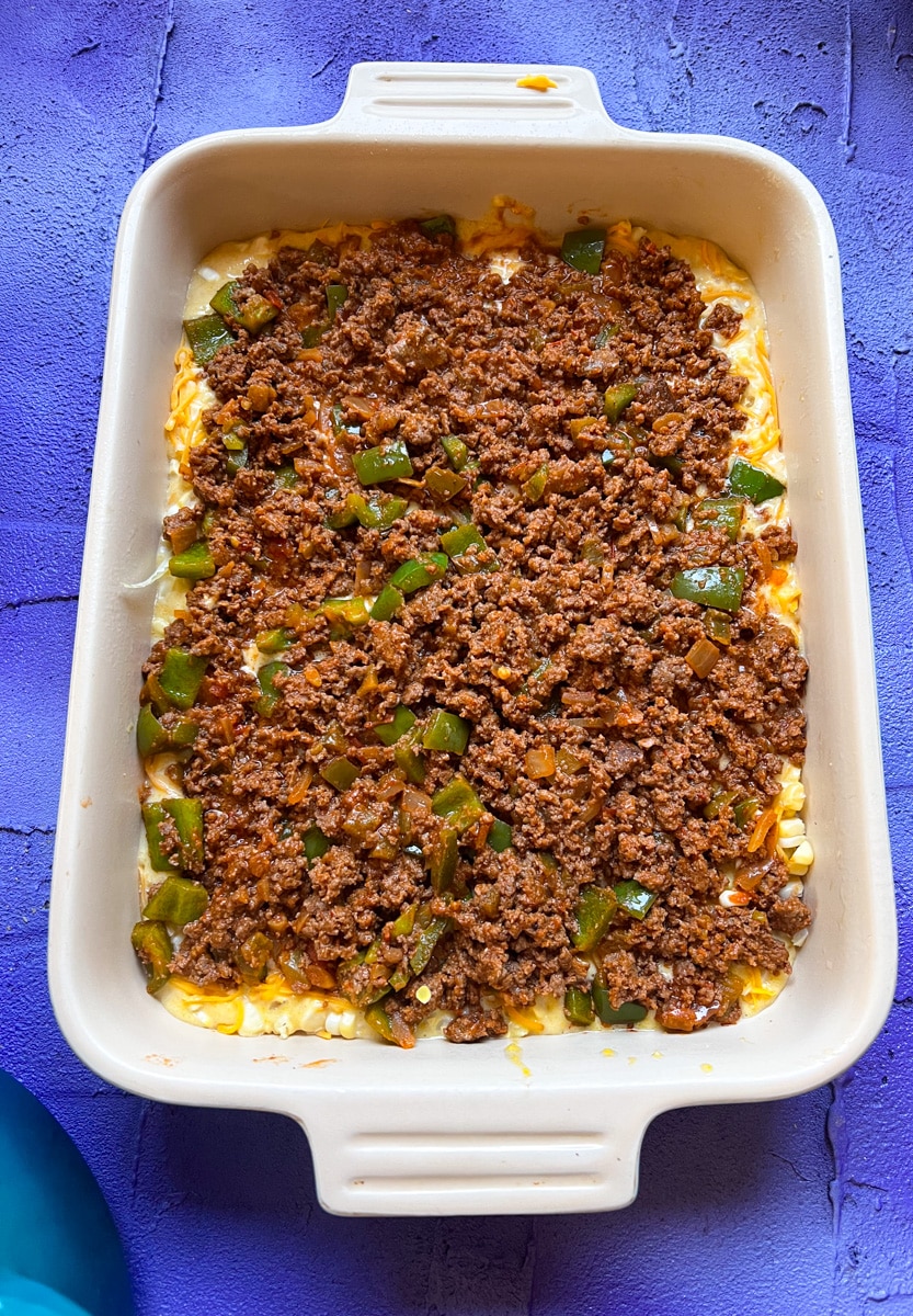 ground beef layer on top of the cheese and cornmeal layer for Texas Tamale Pie
