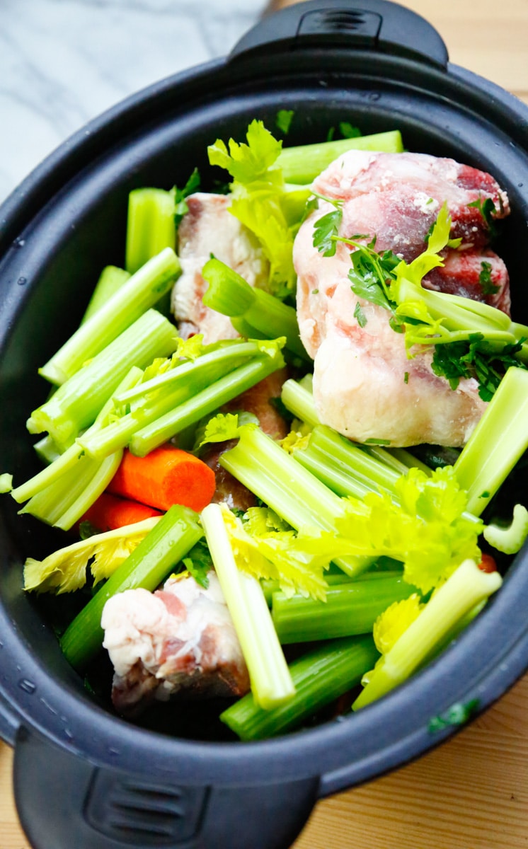 add the celery and carrots to the slow cooker on top of the beef marrow bones 