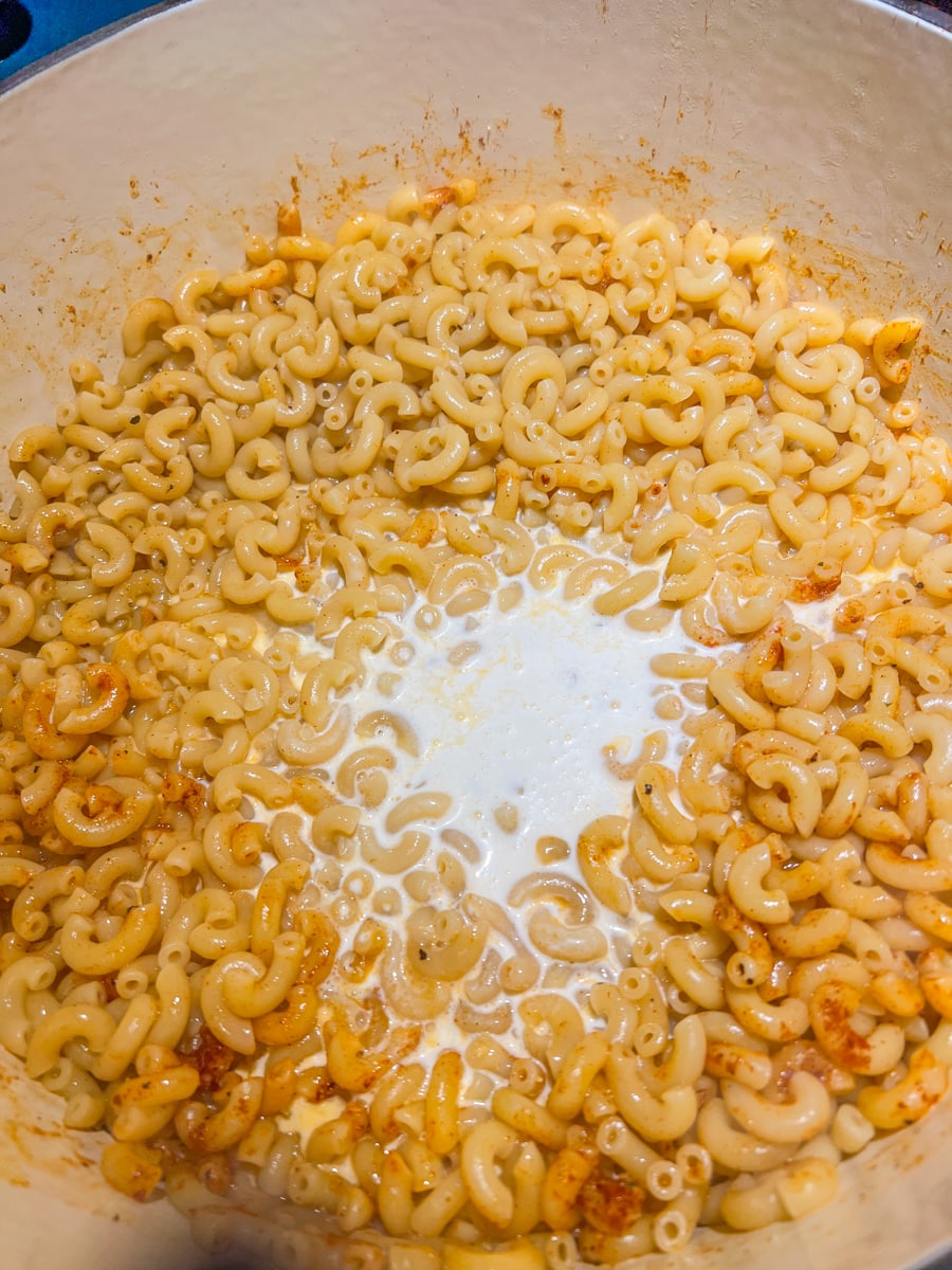 Add the paprika, garlic salt, and black pepper to the cooked pasta. Next add the heavy cream and mix until well combined. 