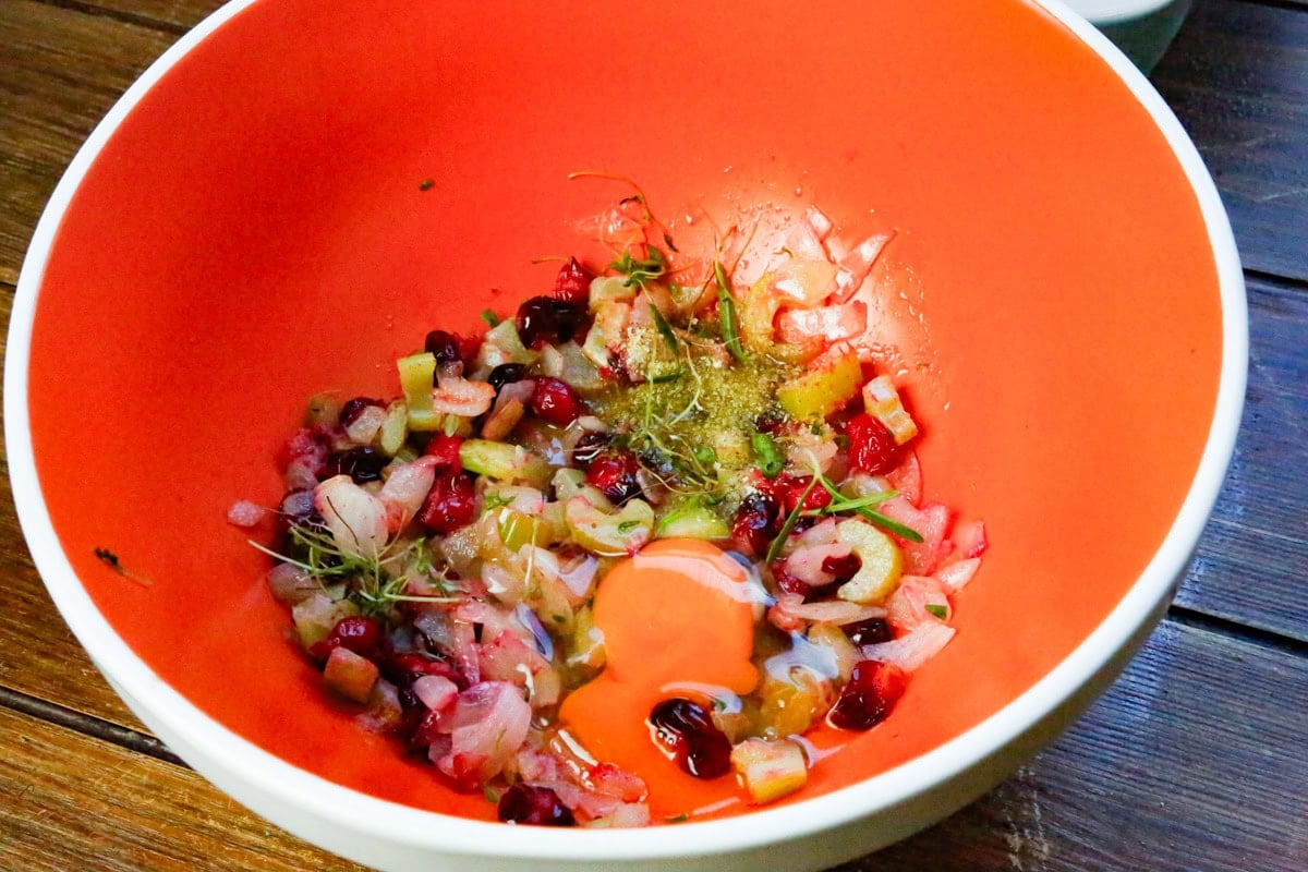 In a large mixing bowl, add the prepped veggies and cranberries, bone broth, egg, fresh sage, thyme, garlic salt, black pepper, and garlic powder, and mix well until combined. 