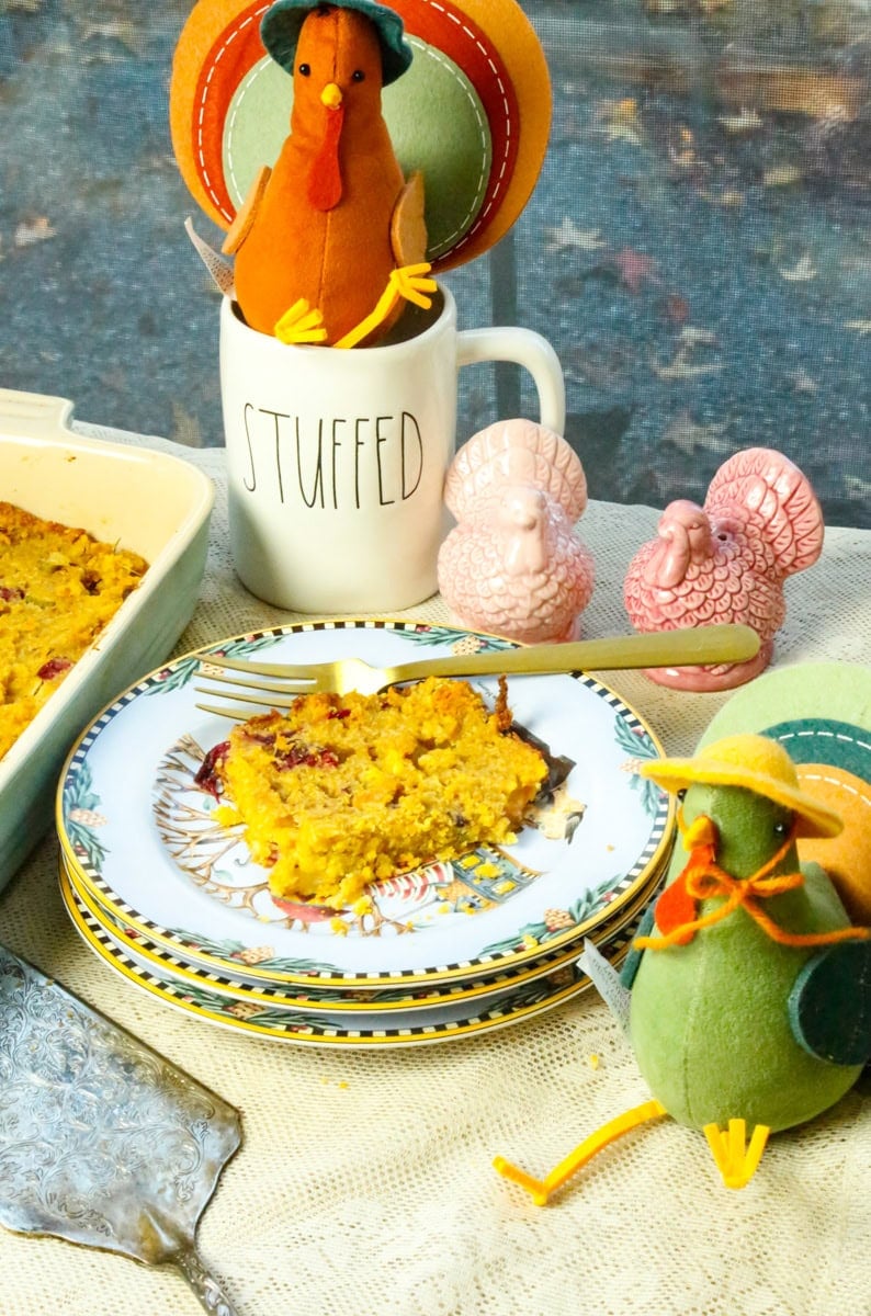 Silver pie server, Christmas plate, turkeys on top of a Rae Dunn mug that says stuffed with a plate of Stove Top stuffing with cornbread and two turkey stuffed animals 