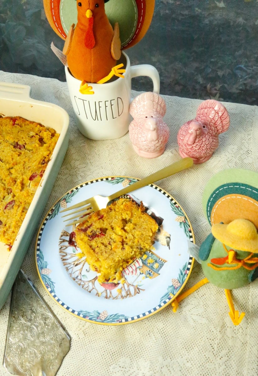 cornbread dressing slice on a plate with stuffed animal turkeys and the mug that says stuffed 