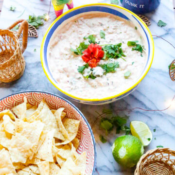 A bowl of Boat Dip with a bowl of tortilla chips and limes