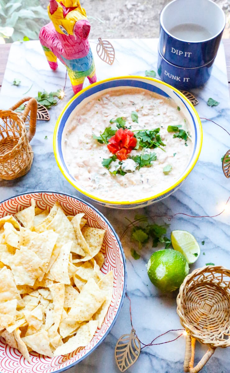 A bowl of Boat Dip with a bowl of tortilla chips and limes 