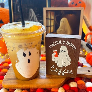 ghost iced coffee viral pumpkin spiced iced coffee with a sign that says freshly boo'd iced coffee