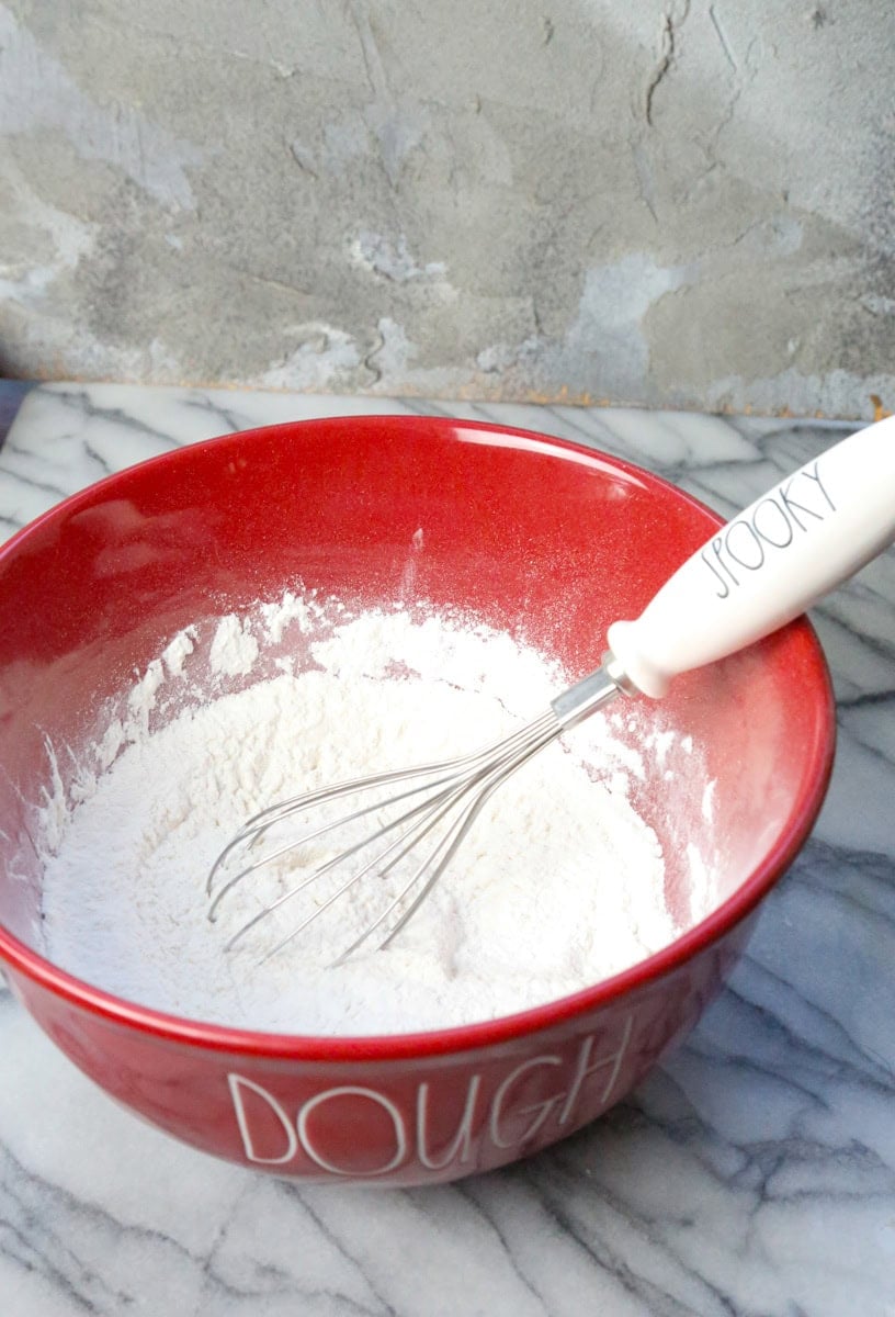 For the pizza dough in a large mixing bowl mix the dry ingredients: whisk together flour, baking powder, and sea salt.