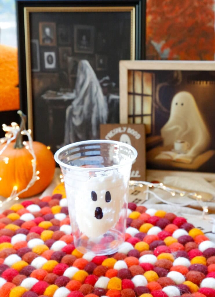 Take your to-go coffee cup and a large spoon and place the back of the spoon in the marshmallow cream and smooth it onto the inside of the cup. You can do this on each side of the cup. This doesn't need to be fancy as these are ghosts. Take a permanent black marker and make the eyes and ghost face on the outside of the cup. 