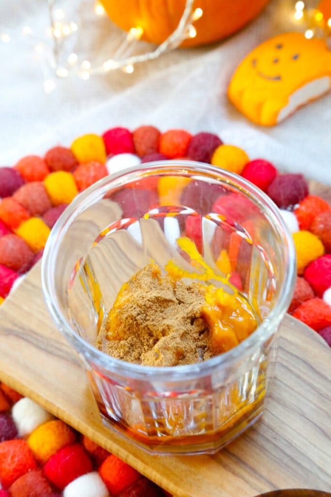 Let's make the pumpkin spice syrup first. In a glass, add the pumpkin puree, maple syrup, and pumpkin spice, and mix until combined. 