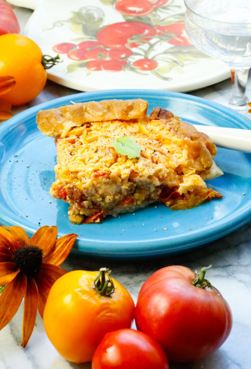 Garnish a slice of fresh tomato pie with sour cream, fresh basil, and more freshly ground black pepper!