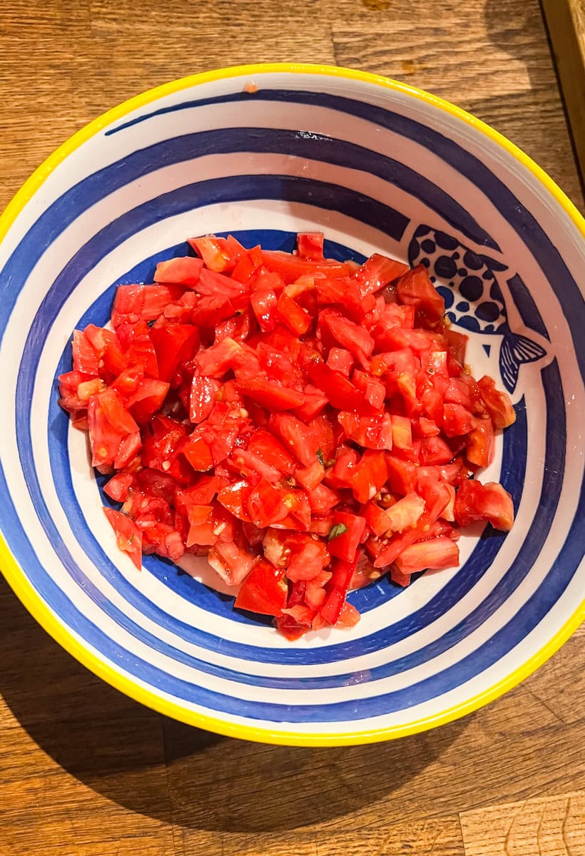 In a bowl, combine the diced tomatoes, olive oil, and red wine vinegar and mix until combined. 