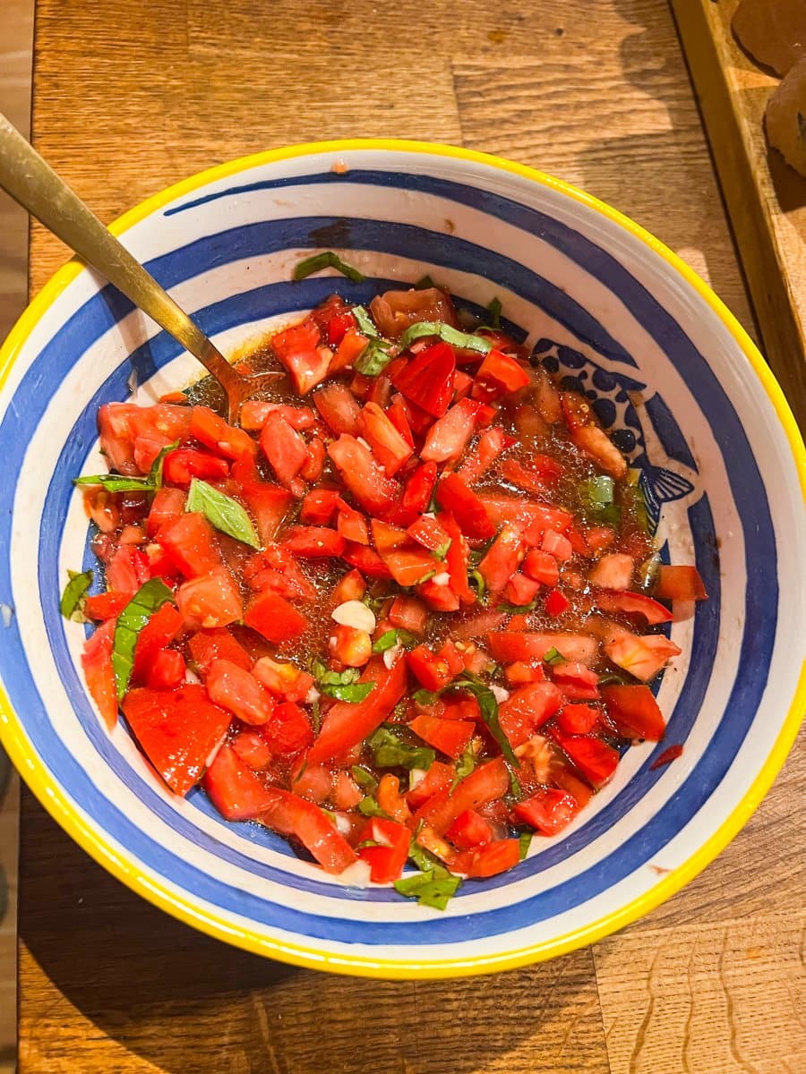 Easy tomato bruschetta in a bowl with a gold spoon