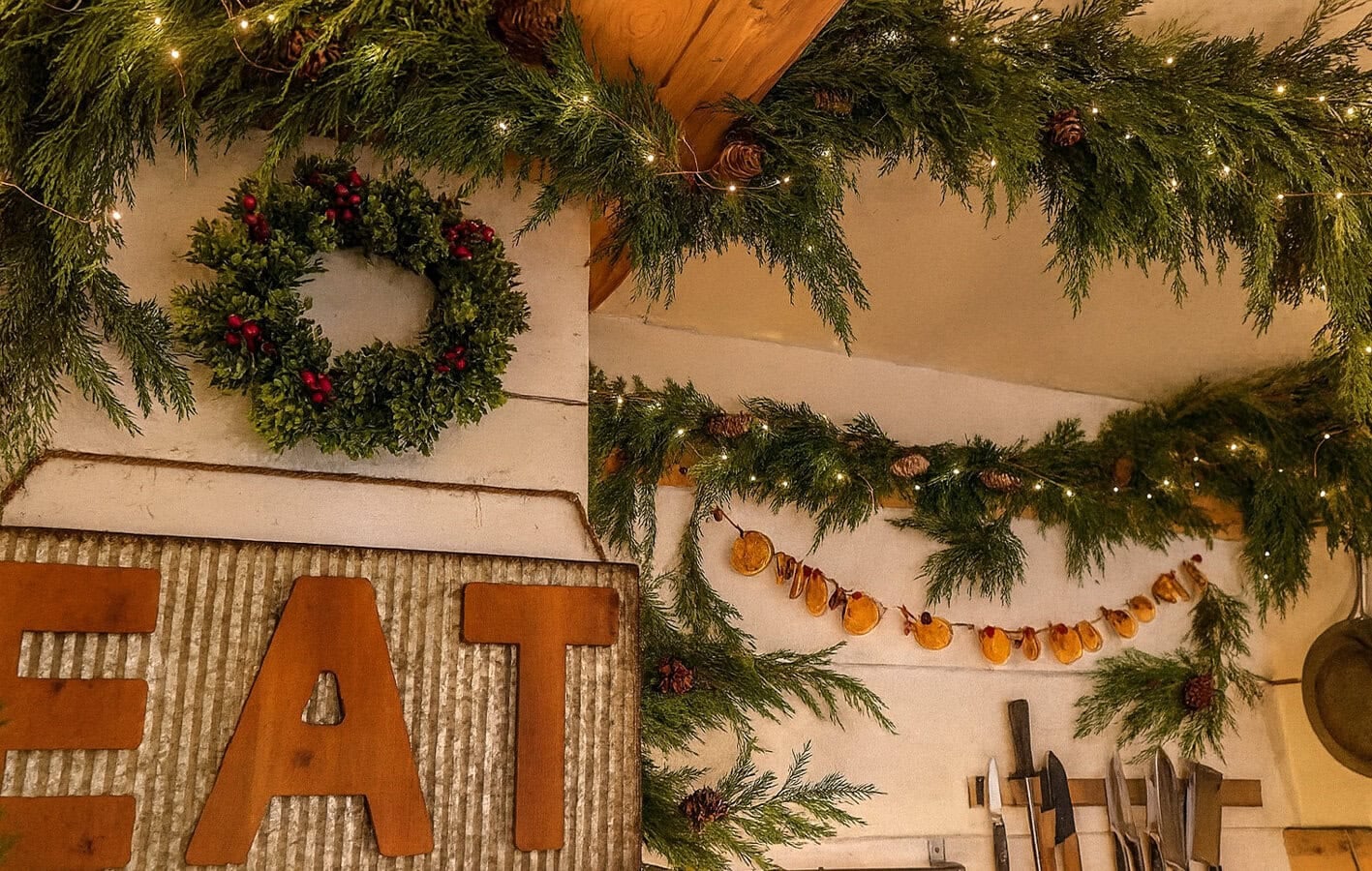 dried orange and clove garland cranberry and dried orange garland hung around fresh garland in a kitchen