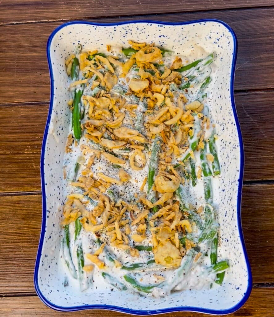 Mix the crispy fried onions into the green bean casserole mixture and add some more crispy fried onions to the top of the green bean casserole as well.