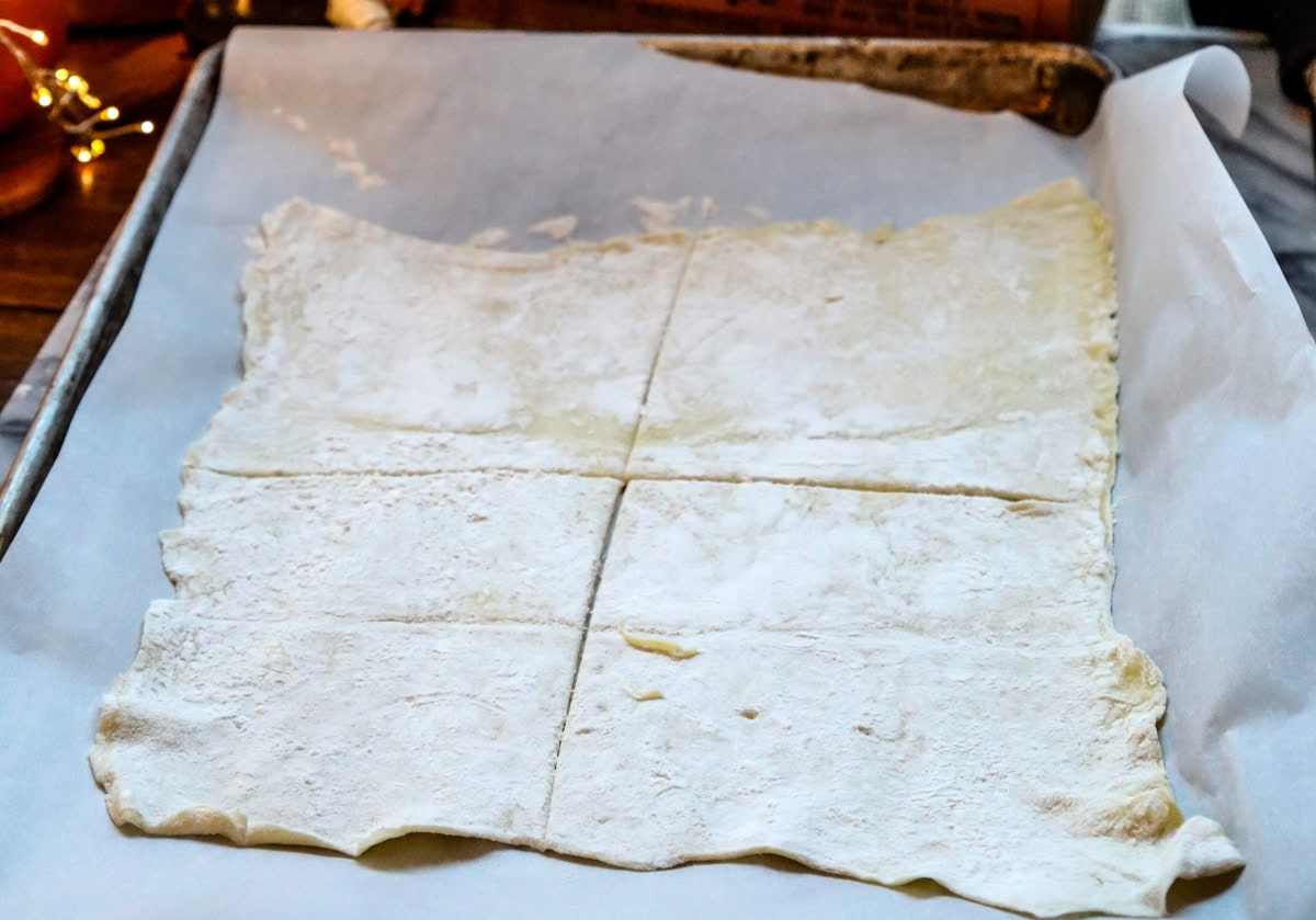 Roll out the thawed puff pastry dough. Using a pizza dough cutter, slice the puff pastry into 4-large rectangles on each sheet. This should make 8-total rectangles, one for the bottom and top of the pop tarts.