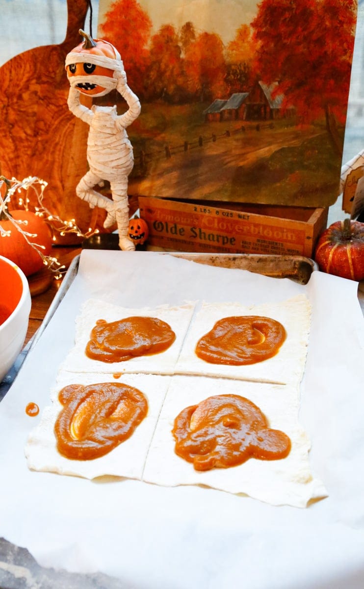 Take a spoon and add a dollop of pumpkin pie mixture to the center of the bottom puff pastry rectangle.