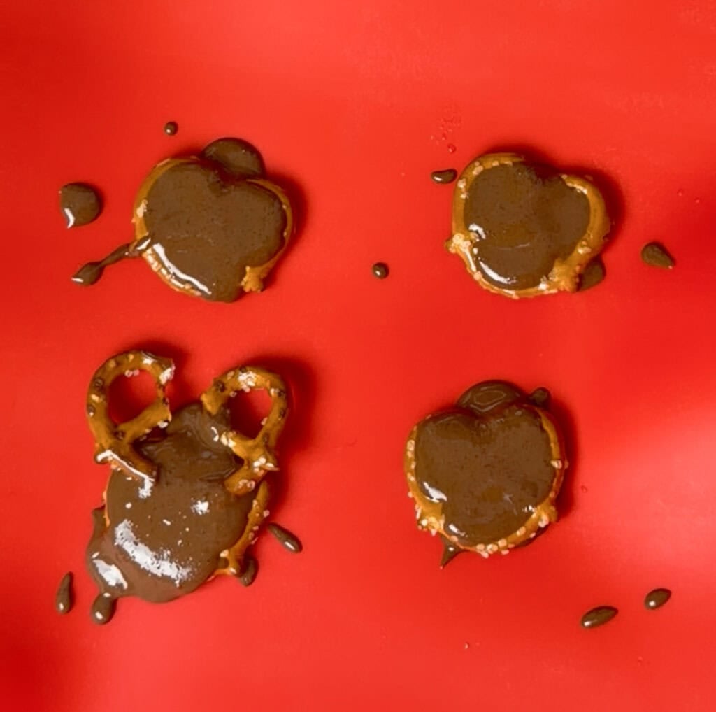 Add the chocolate: Spoon or pipe a small amount of melted chocolate into the center of each pretzel.