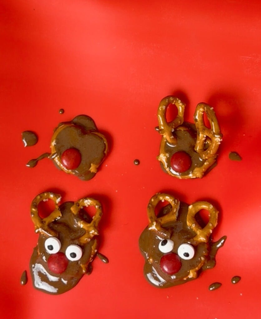 Attach the face: Press a red candy into the chocolate to create the nose.