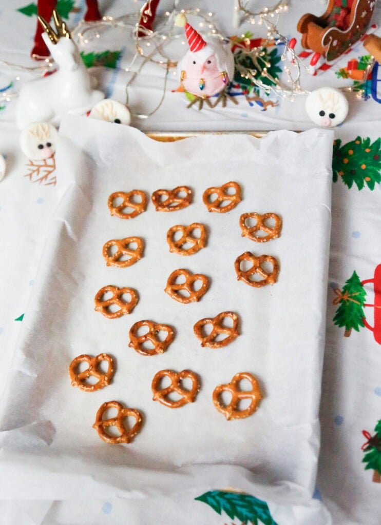 Arrange the pretzels on the prepared baking sheet, placing them flat so the open ends form the reindeer “antlers.”