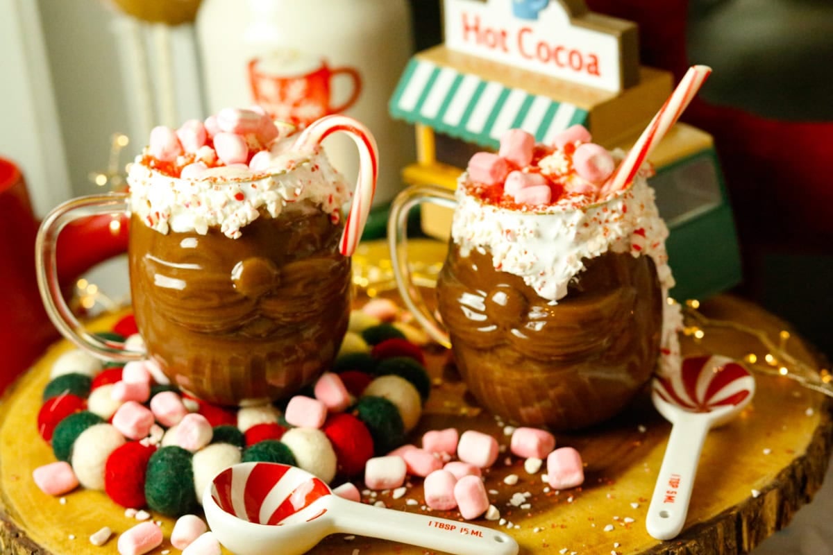Top with whipped cream, peppermint marshmallows, Christmas sprinkles and add a candy cane inside the mug for a festive touch. Serve and enjoy immediately!