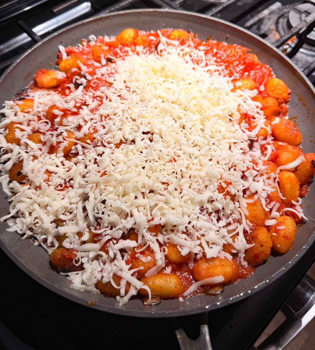 Shred half of the Mozzarella cheese and layer it on top of the prepared gnocchi and then add in some pepperoni slices.