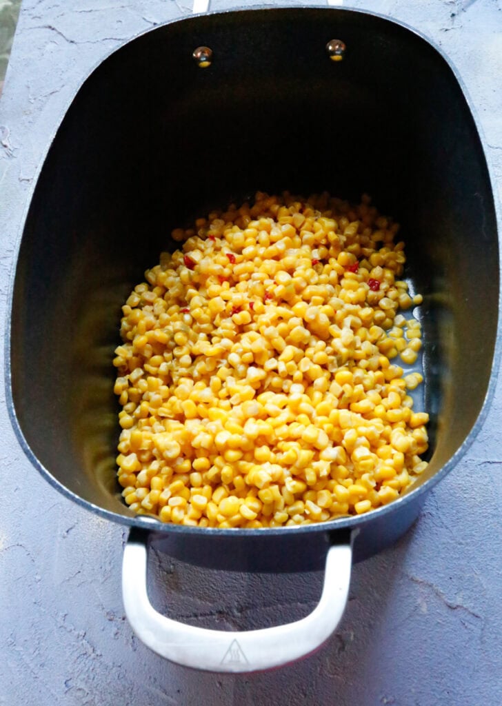 Sweet corn added to a slow cooker as the base for creamy Mexican street corn dip