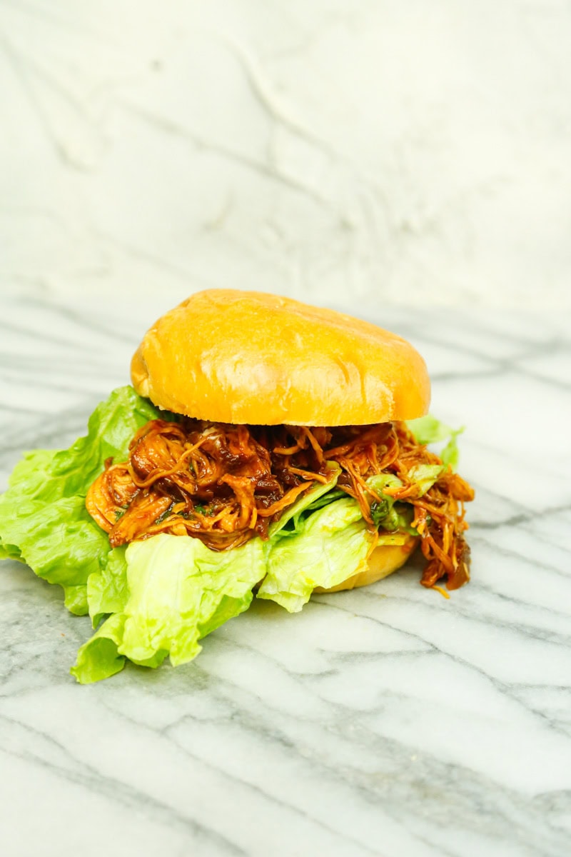 BBQ chicken sandwiches slow cooker recipe on soft bun with saucy shredded chicken