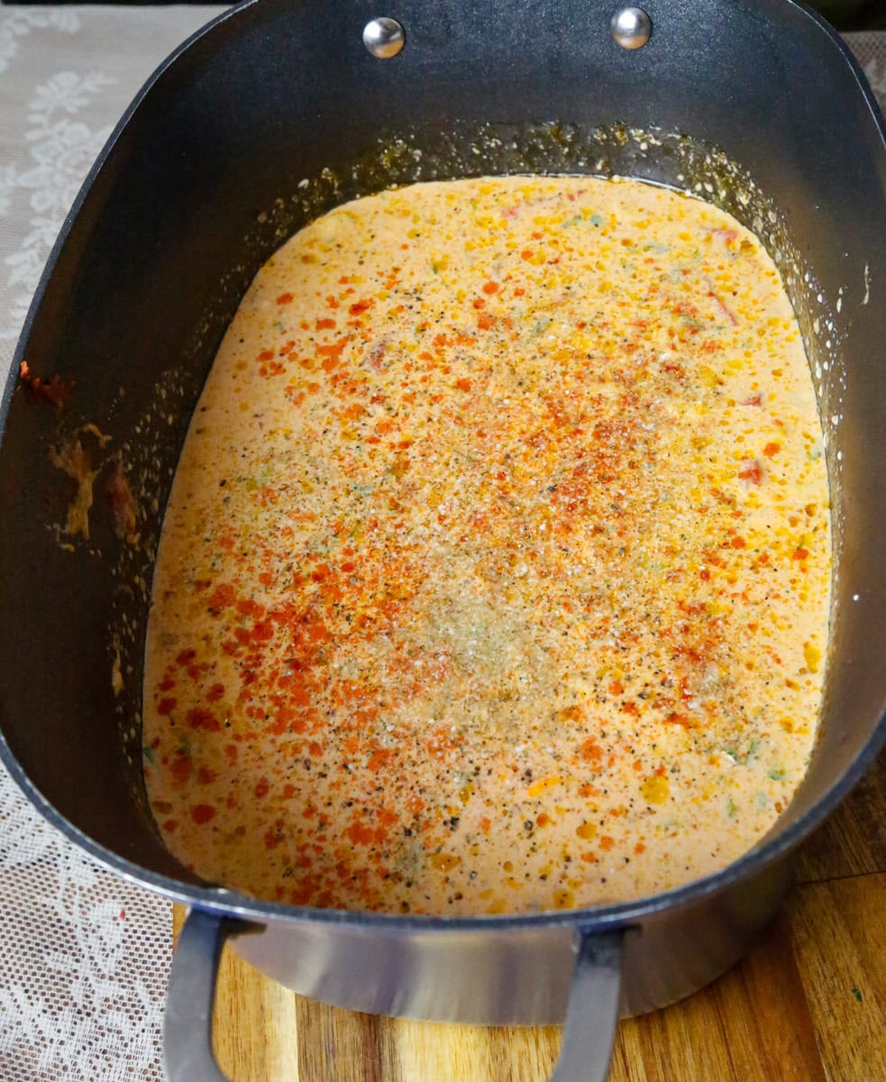 Creamy slow cooker ravioli soup base simmering in a pot before adding ravioli