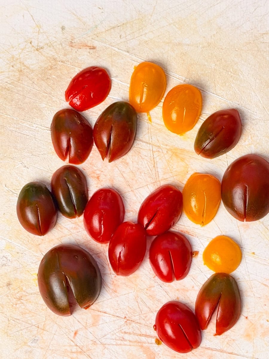 tricolor cherry tomatoes with slit cuts to create ladybug wings for ladybug crostini appetizer