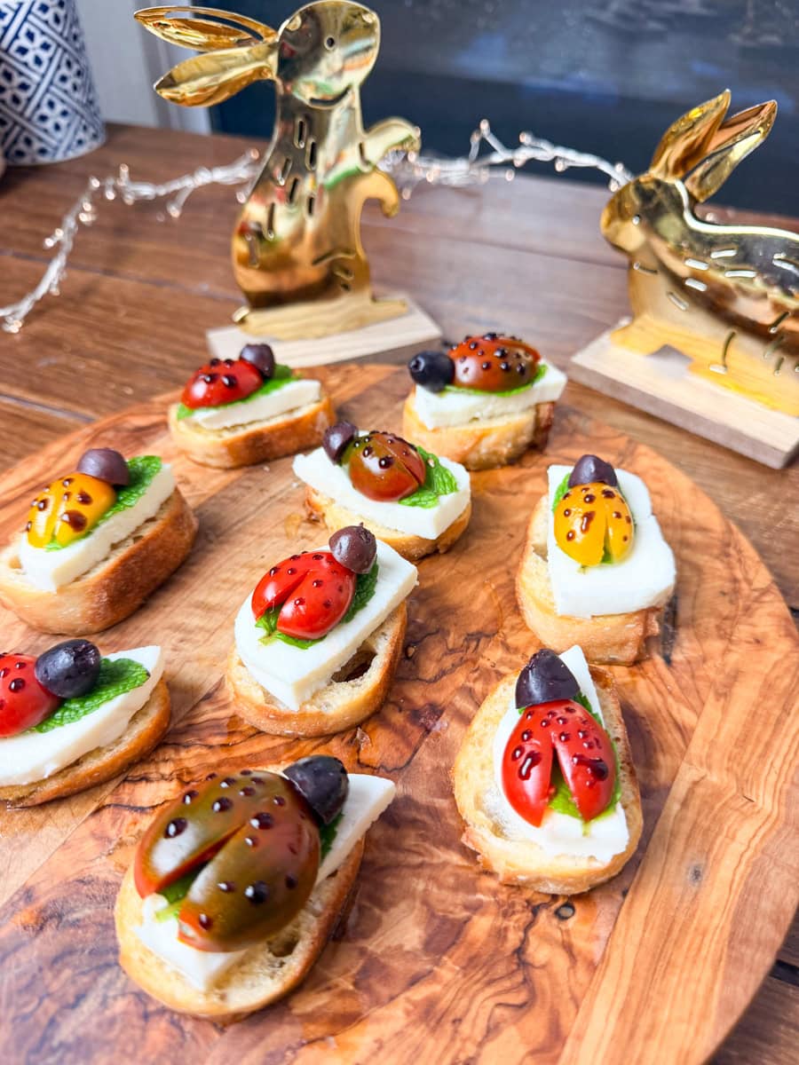 ladybug crostini appetizer with cherry tomatoes mozzarella basil leaves and balsamic glaze spots on toasted bread